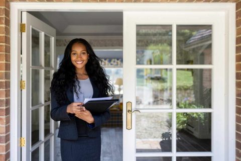 Property management professional welcoming clients at the entrance of a rental property